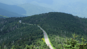 A ribbon of highway cut through green mountains looks like the Blue Ridge Parkway